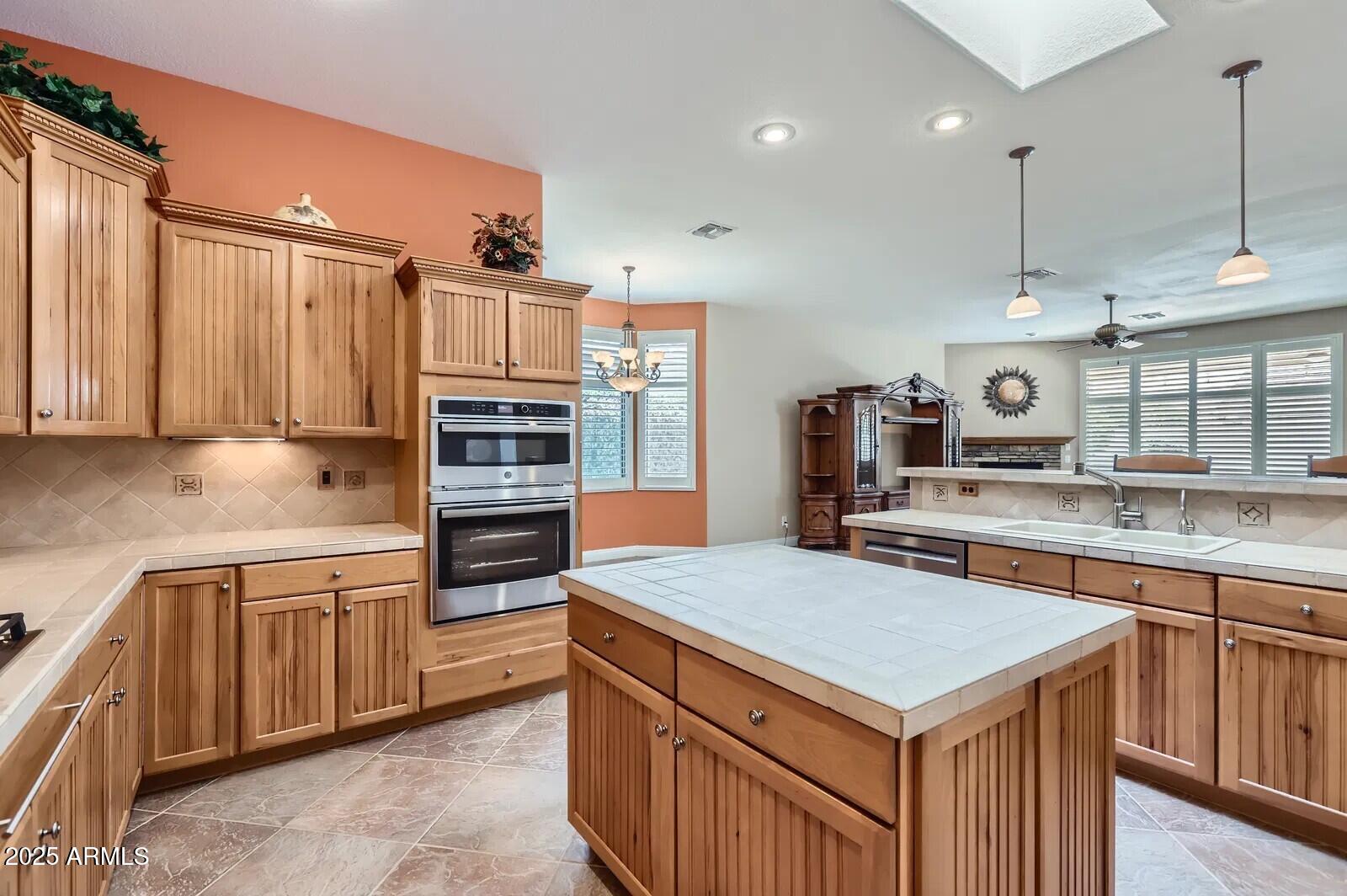 17951 West Sammy Way Surprise, AZ 85374 - Photo 9 of 24 a kitchen that has a lot of cabinets in it and wooden floors