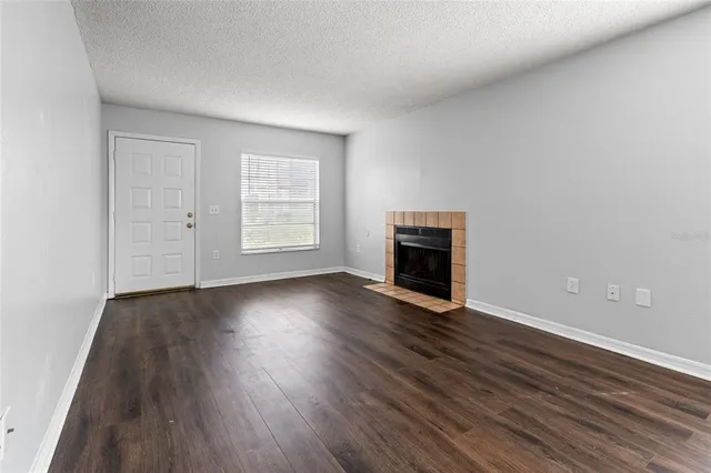 an empty room with wooden floor and fireplace