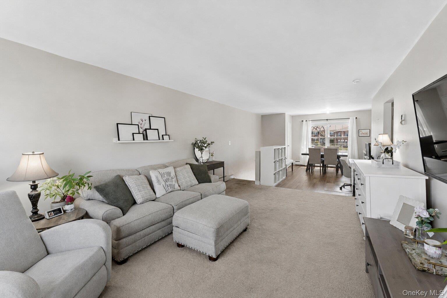 323 Hicksville Road, Unit 4 Bethpage, NY 11714 - Photo 3 of 17 a living room with furniture and a flat screen tv