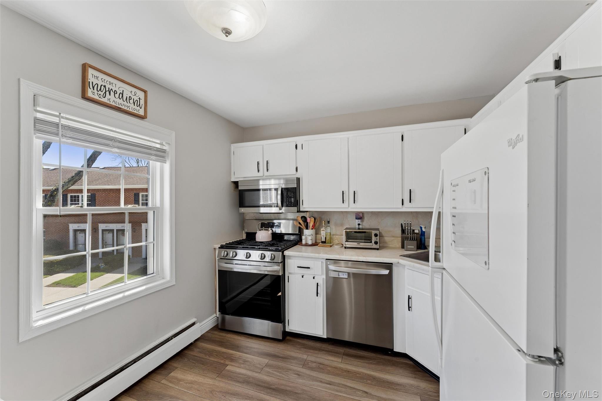 323 Hicksville Road, Unit 4 Bethpage, NY 11714 - Photo 7 of 17 a kitchen with a stove a sink and a refrigerator