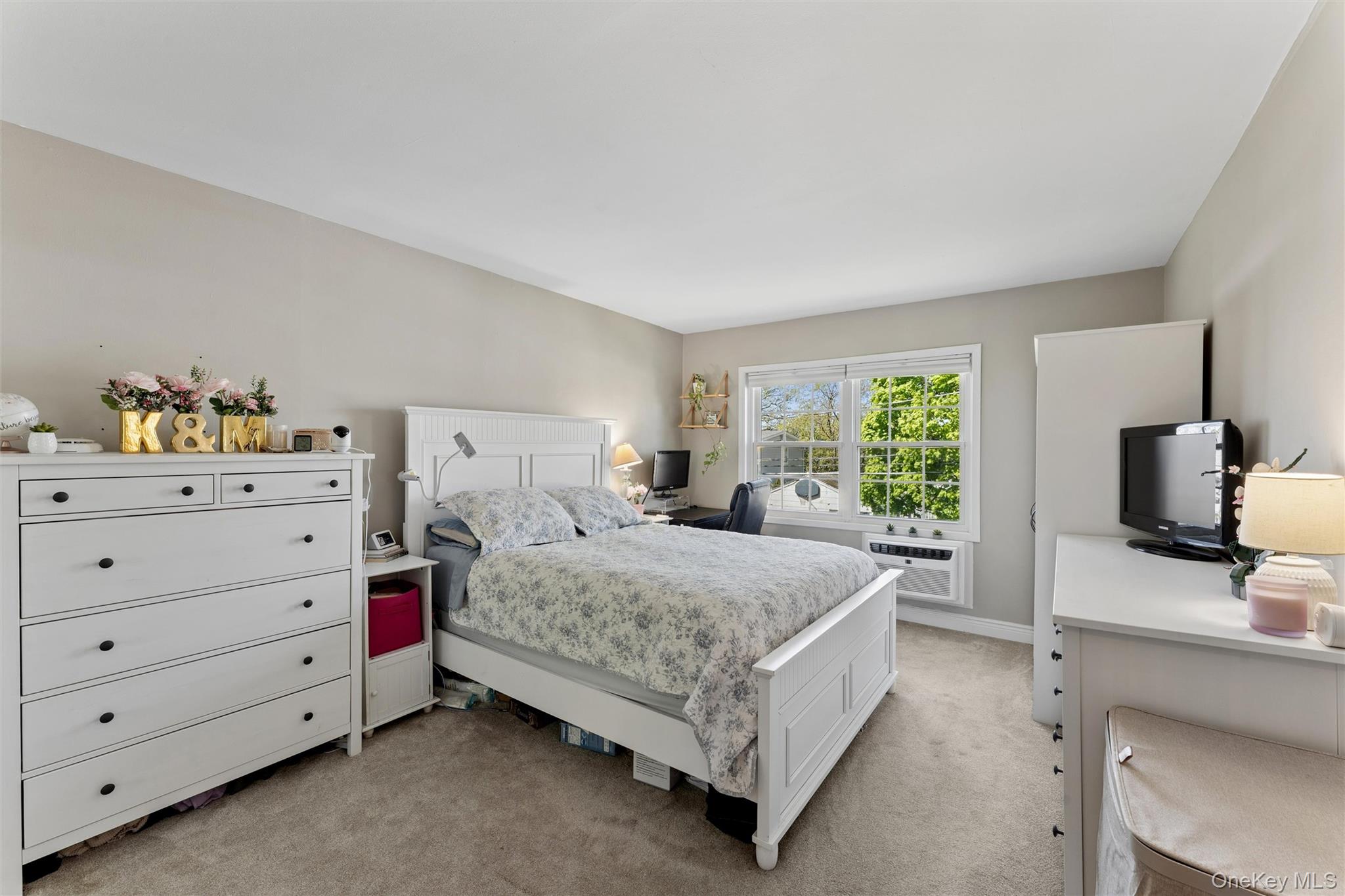 323 Hicksville Road, Unit 4 Bethpage, NY 11714 - Photo 8 of 17 a bedroom with a bed and large windows