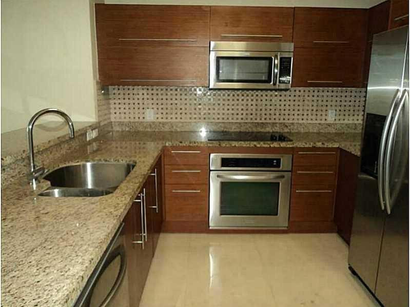2681 North Flamingo Road, Unit 2604S Plantation, FL 33323 - Photo 11 of 16 a kitchen with a stove a sink and a microwave