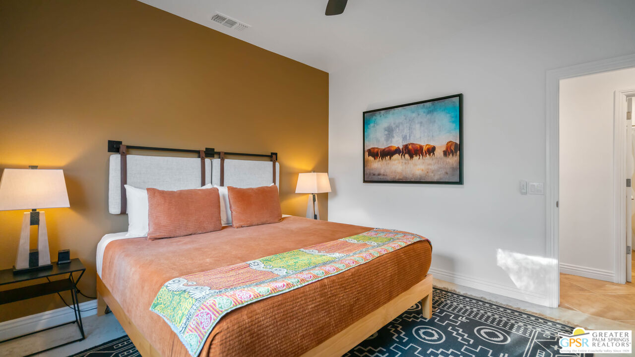 7514 Sunset Road Joshua Tree, CA 92252 - Photo 29 of 69 a bedroom with a bed and a lamp with wooden floor