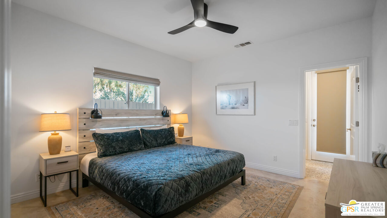 7514 Sunset Road Joshua Tree, CA 92252 - Photo 38 of 69 a bedroom with a bed lamp and a window