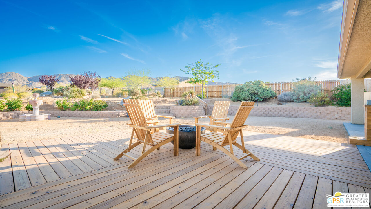 7514 Sunset Road Joshua Tree, CA 92252 - Photo 46 of 69 a view of a roof deck with table and chairs a barbeque with wooden floor and fence