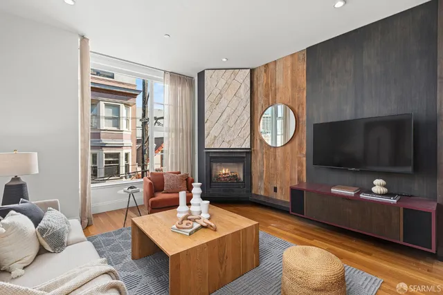 a living room with furniture a flat screen tv and a window