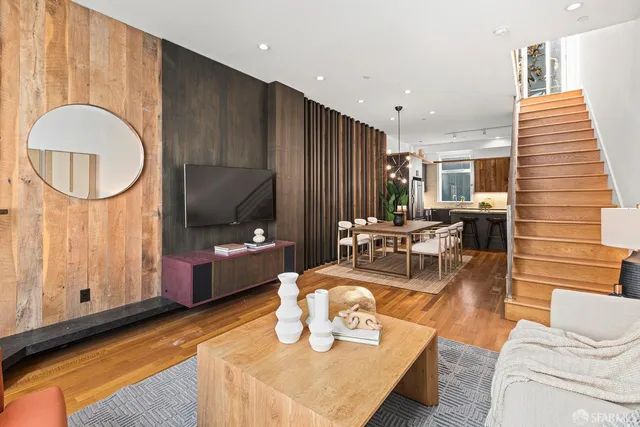 a living room with furniture a flat screen tv and a large window
