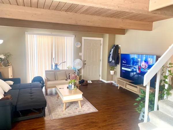 a living room with furniture wooden floor and a large window