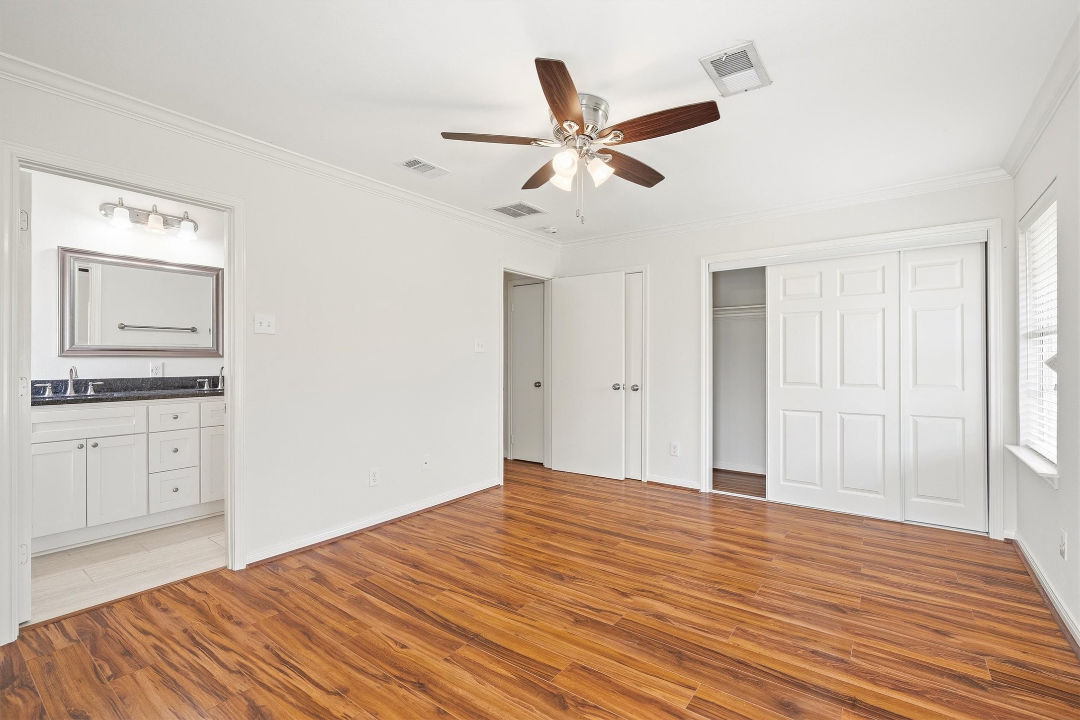 3331 Arbor Street Houston, TX 77004 - Photo 23 of 30 A view to the primary bedroom en-suite bathroom with a modern vanity and ample natural light from the windows.