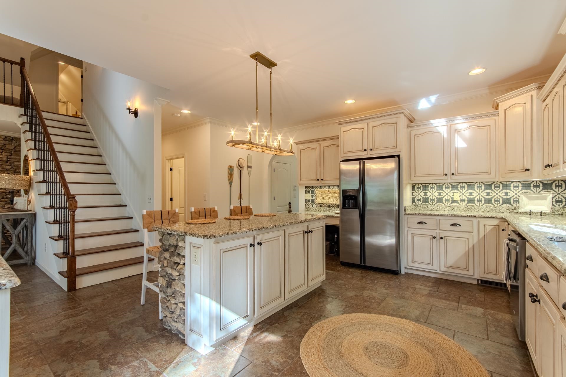 120 Pier Point Savannah, TN 38372 - Photo 12 of 38 Kitchen with backsplash, light stone counters, appliances with stainless steel finishes, pendant lighting, and crown molding