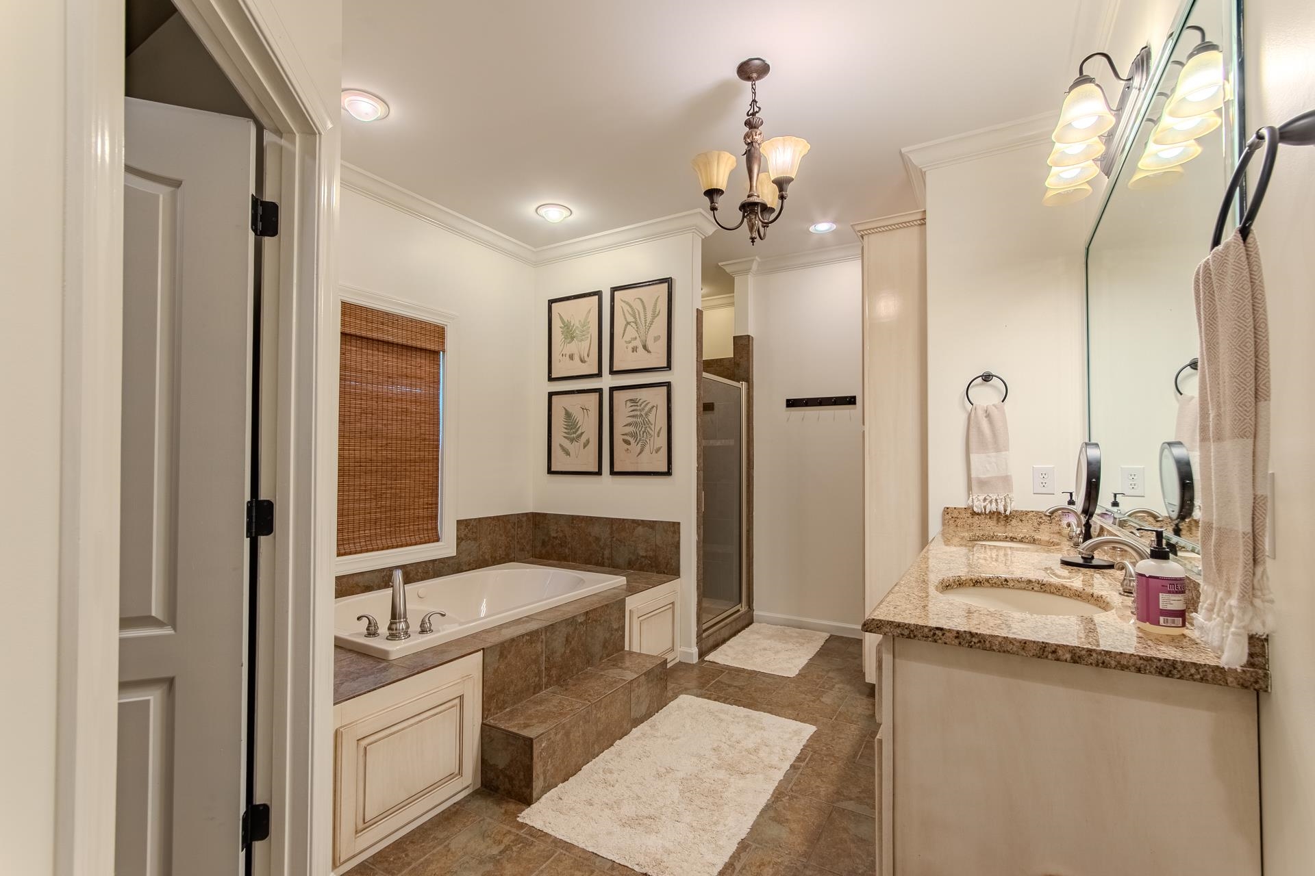 120 Pier Point Savannah, TN 38372 - Photo 22 of 38 Bathroom with a bath, double vanity, a shower stall, ornamental molding, and a chandelier