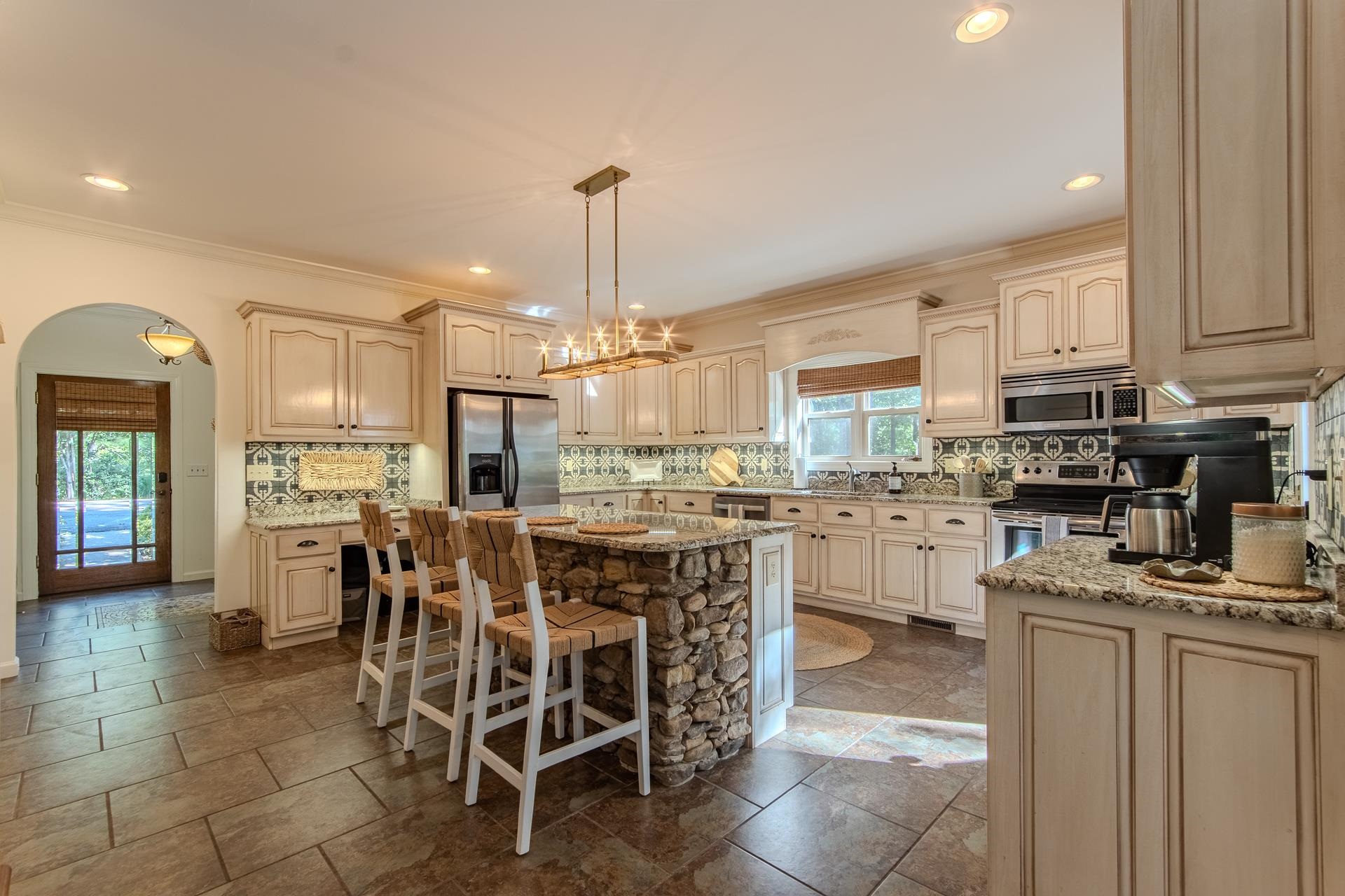 120 Pier Point Savannah, TN 38372 - Photo 7 of 38 Kitchen featuring a kitchen breakfast bar, tasteful backsplash, decorative light fixtures, stainless steel appliances, and ornamental molding