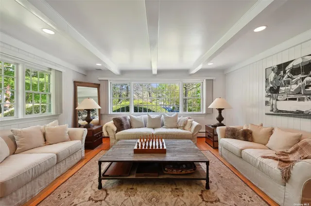 a living room with furniture a large window and a dining table