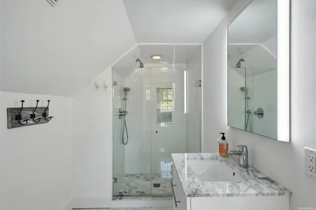 a bathroom with a granite countertop sink a shower and a mirror