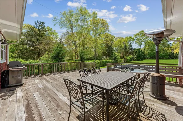 a view of a patio with table and chairs with wooden floor and fence