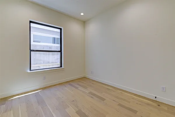 a view of an empty room with wooden floor