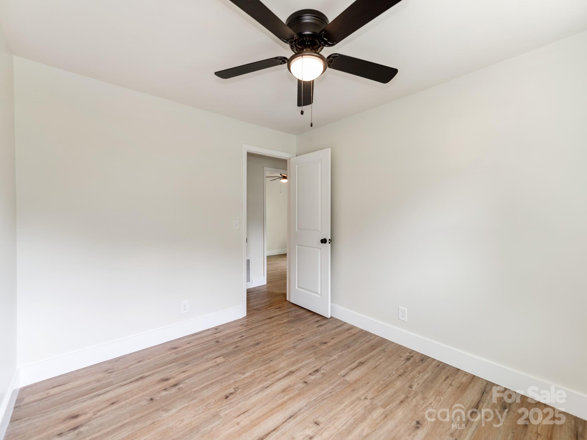 5404 Hope Road Vale, NC 28168 - Photo 14 of 28 a view of an empty room and window a ceiling fan and wooden floor