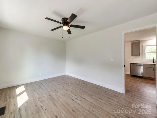 a view of a room with wooden floor and a ceiling fan