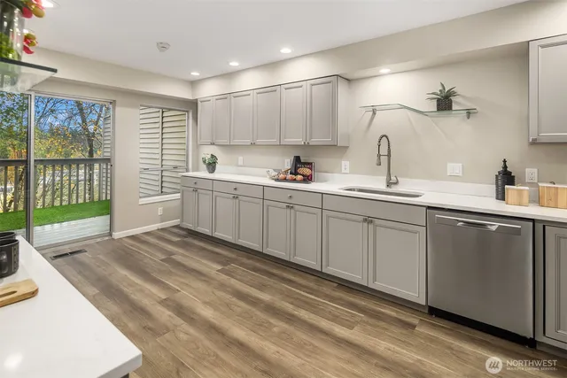 a spacious bathroom with a double vanity sink a mirror and next to a window
