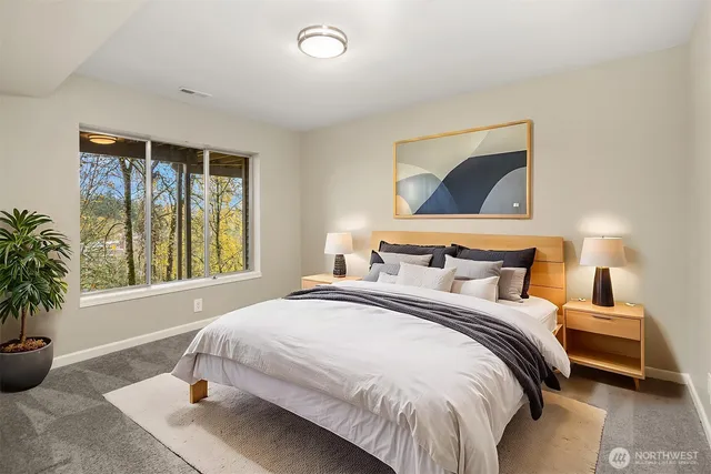 a bedroom with bed and large windows