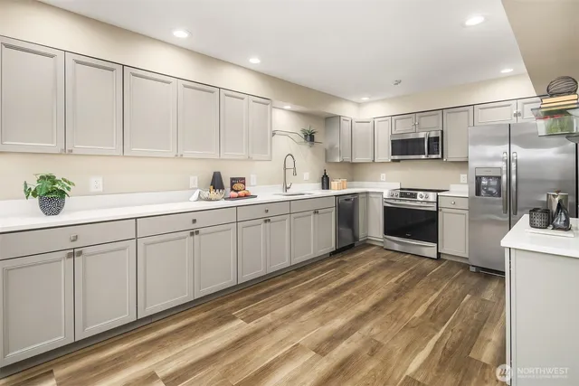 a kitchen with white cabinets sink and stainless steel appliances