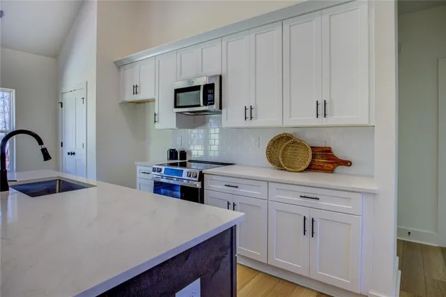 a kitchen with white cabinets and appliances