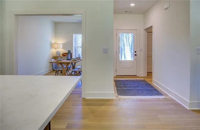 a view of a hallway with wooden floor and staircase