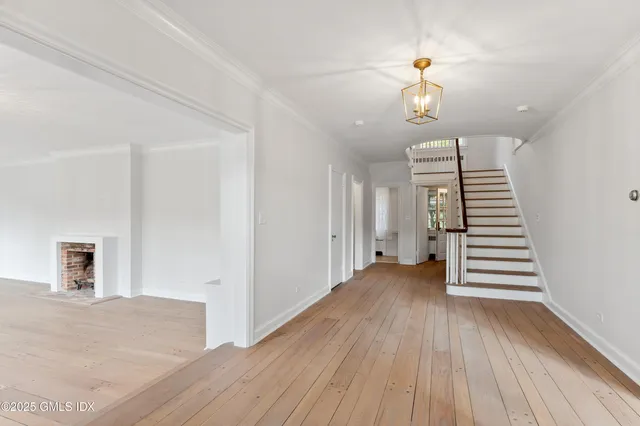 wooden floor in an empty room with a chandelier