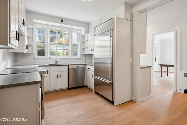 a kitchen with stainless steel appliances granite countertop a refrigerator and a sink