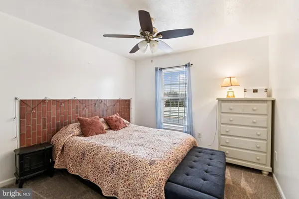 a bedroom with a bed and ceiling fan