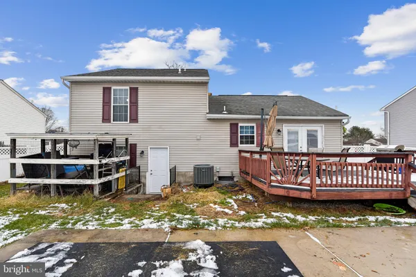a view of a house with wooden deck and a yard