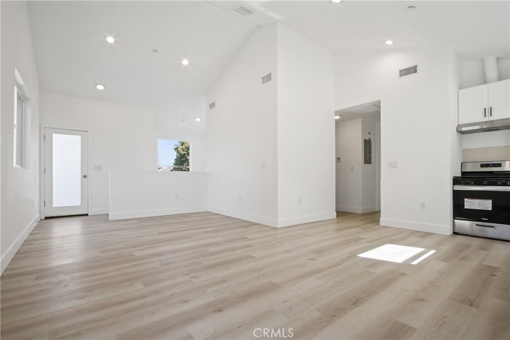 9241 1/2 Firth Boulevard, Unit 1/2 Los Angeles, CA 90002 - Photo 4 of 25 a view of empty room with wooden floor and kitchen