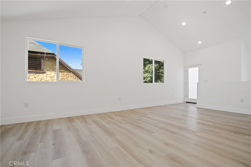 9241 1/2 Firth Boulevard, Unit 1/2 Los Angeles, CA 90002 - Photo 6 of 25 an empty room with wooden floor and windows