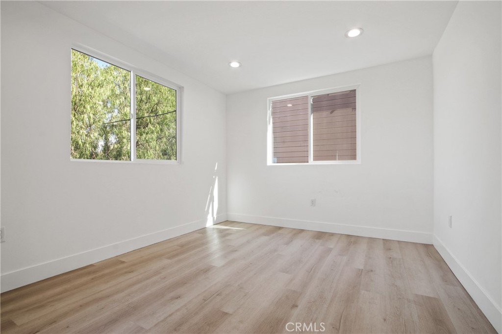 9241 1/2 Firth Boulevard, Unit 1/2 Los Angeles, CA 90002 - Photo 9 of 25 an empty room with wooden floor and windows