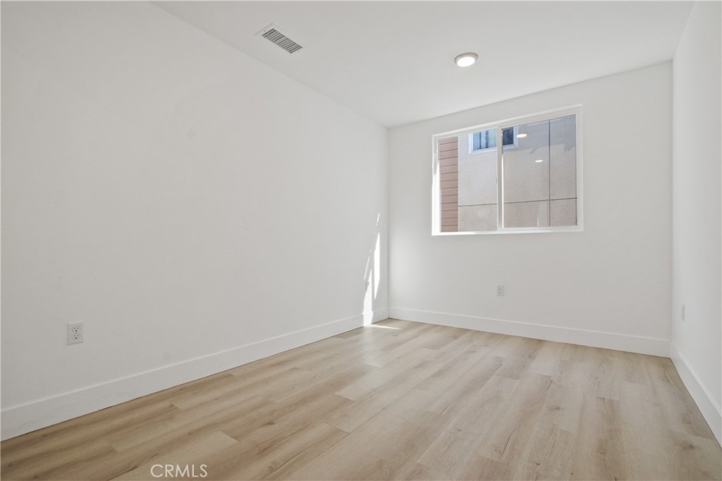 9241 1/2 Firth Boulevard, Unit 1/2 Los Angeles, CA 90002 - Photo 10 of 25 an empty room with wooden floor and windows