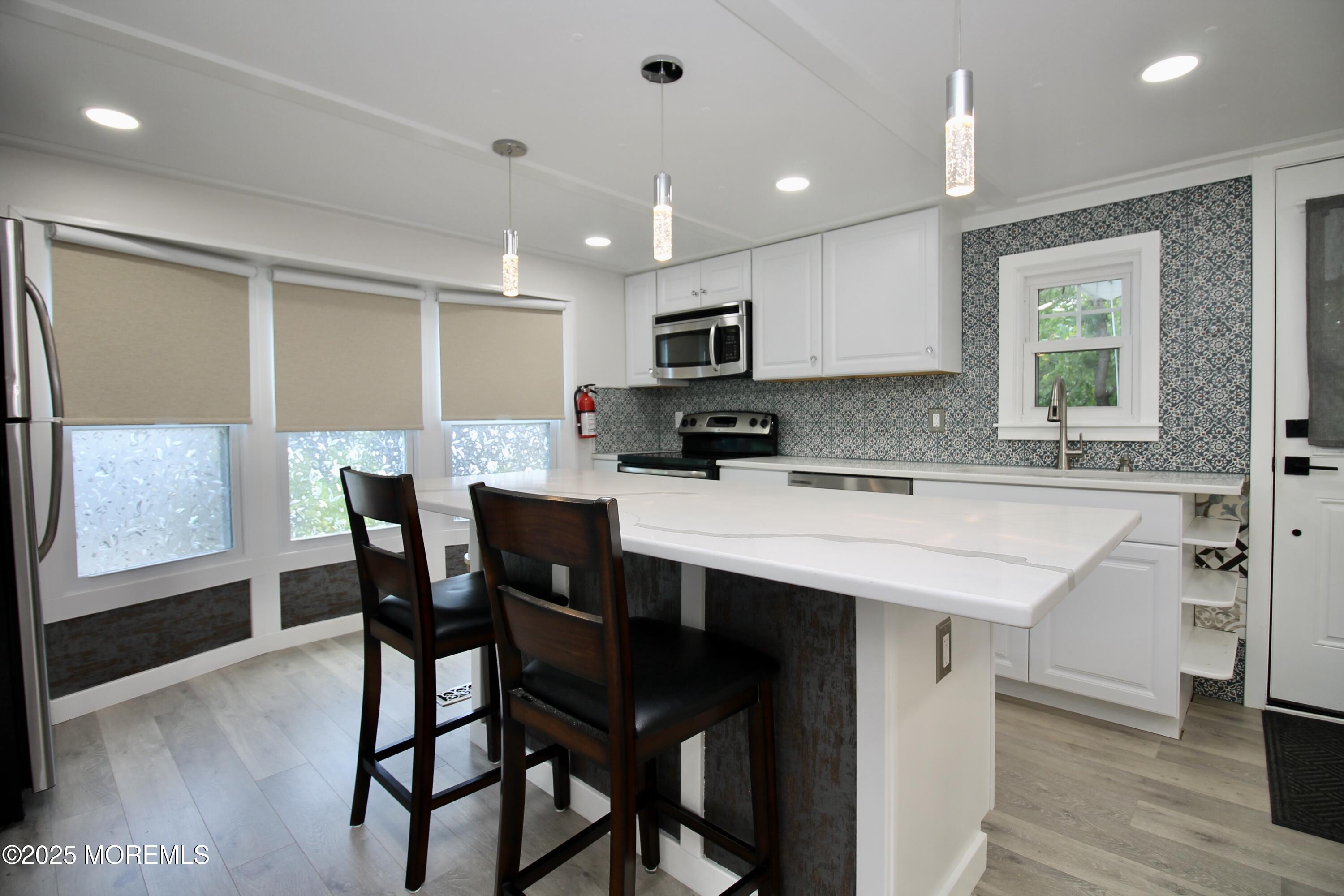 41 Eagle Drive Whiting, NJ 08759 - Photo 15 of 31 a kitchen with stainless steel appliances kitchen island granite countertop a table chairs sink and cabinets
