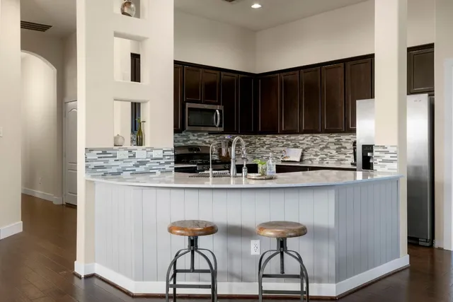 a kitchen with stainless steel appliances granite countertop a stove top oven a sink and cabinets