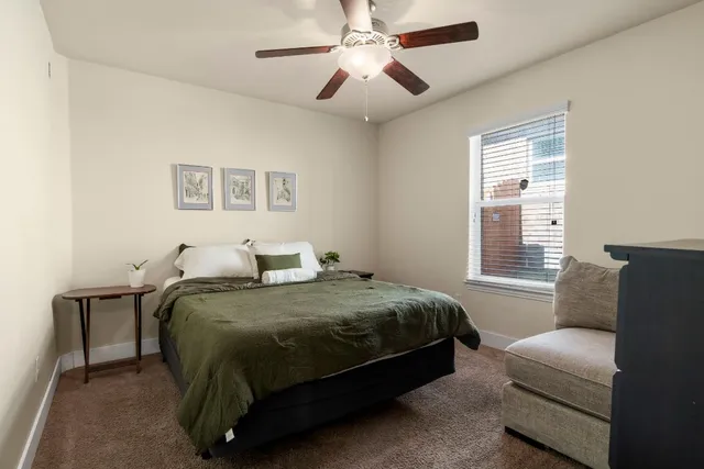 a bedroom with a bed couch and window