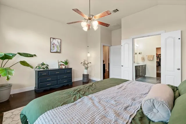 a bedroom with a bed and a chandelier fan