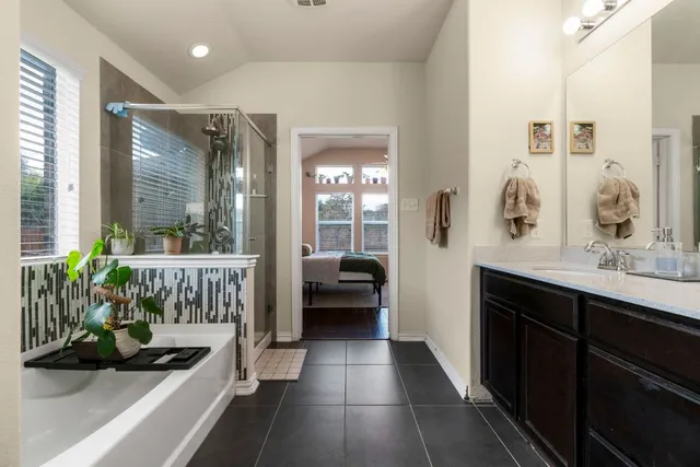 a bathroom with a tub sink and mirror