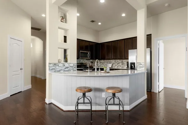 a kitchen with stainless steel appliances granite countertop a refrigerator and a stove top oven
