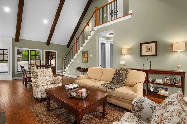 a dining room with furniture a chandelier and wooden floor