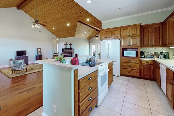 a kitchen that has a lot of cabinets in it and wooden floors