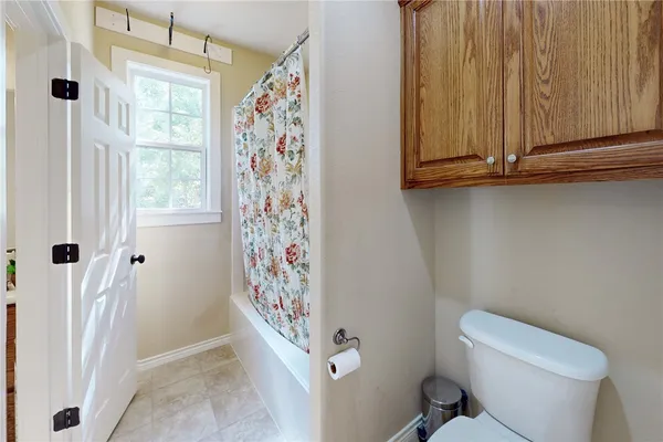 a bathroom with a toilet and shower curtain