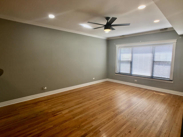 5934 North Paulina Street, Unit 2 Chicago, IL 60660 - Photo 5 of 12 an empty room with wooden floor fan and windows