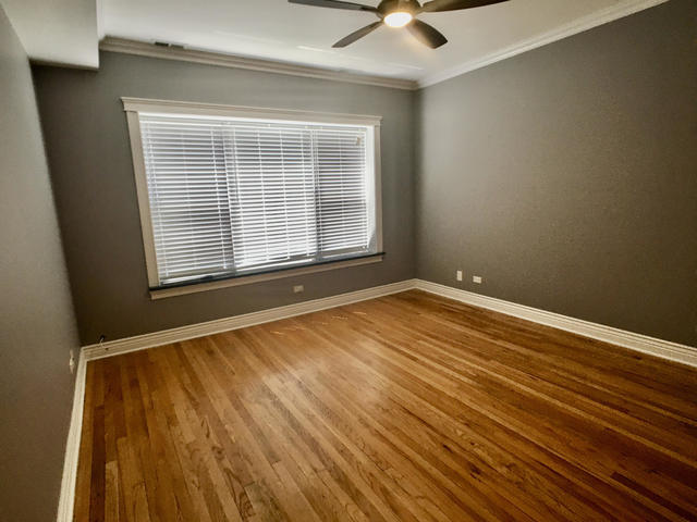 5934 North Paulina Street, Unit 2 Chicago, IL 60660 - Photo 6 of 12 a view of an empty room with a window and wooden floor
