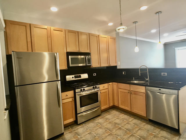 5934 North Paulina Street, Unit 2 Chicago, IL 60660 - Photo 7 of 12 a kitchen with granite countertop a refrigerator a sink a stove a microwave and island