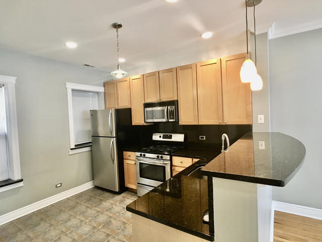 5934 North Paulina Street, Unit 2 Chicago, IL 60660 - Photo 8 of 12 a kitchen with kitchen island a counter top space appliances and a window