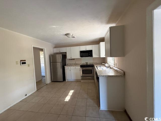 1909 9th Avenue Conway, SC 29527 - Photo 4 of 15 Kitchen with light countertops, appliances with stainless steel finishes, white cabinetry, and light tile patterned floors