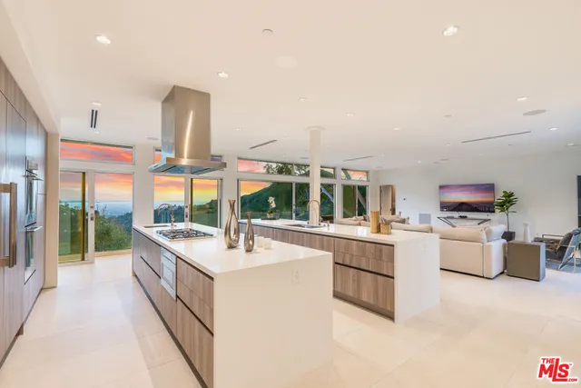 a large white kitchen with a large window and white cabinets